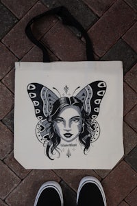 a tote bag with an image of a woman with a butterfly on it
